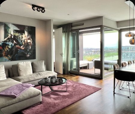 Hell eingerichtetes Wohnzimmer einer Eigentumswohnung